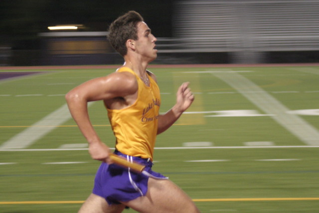 Ben Fogg kicks in the third leg to help Lake Braddock win the boys' race at the Braddock Relays. Photo: Charlie Ban