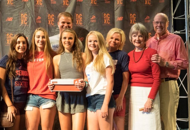 Grace Dallapa (holding the shoe box) surrounded by family and teammates at the 2015 All-RunWashington pep rally. She was on the All-Maryland team for the second year in a row. Photo: Roger Colazzi