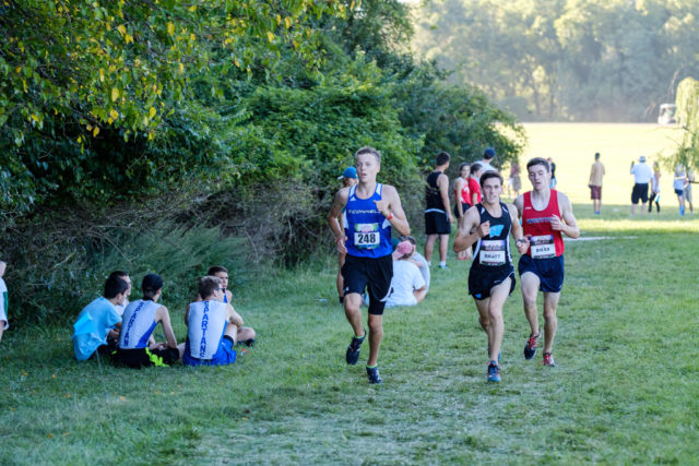 Max Grecyn runs alongside Aaron Bratt and John Riker in the third mile of the junior boys' race. Photo: Dustin Whitlow/DWhit Photography